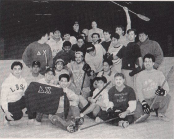 A vintage black-and-white photo of a large group of young men posing indoors.